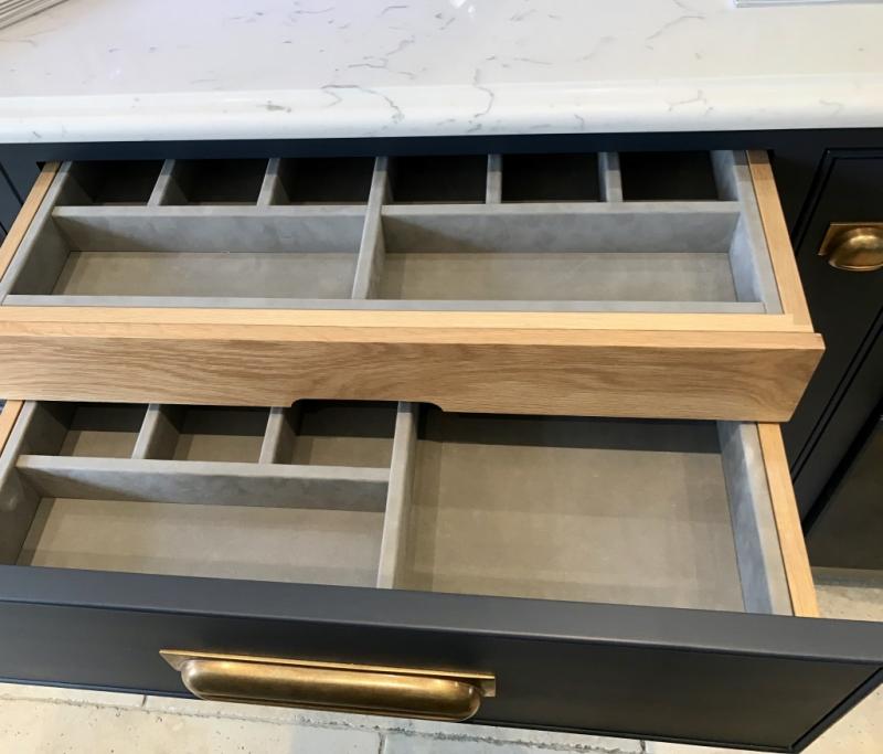 A double tier, oak-lined cutlery drawer.